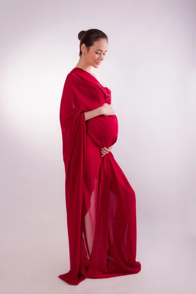 Donna incinta nei tessuti rossi — Foto Stock