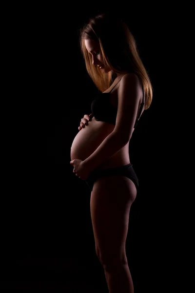 Jonge zwangere vrouwen op zwarte achtergrond — Stockfoto