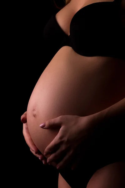 Lichaam van de jonge zwangere in zwarte ondergoed — Stockfoto