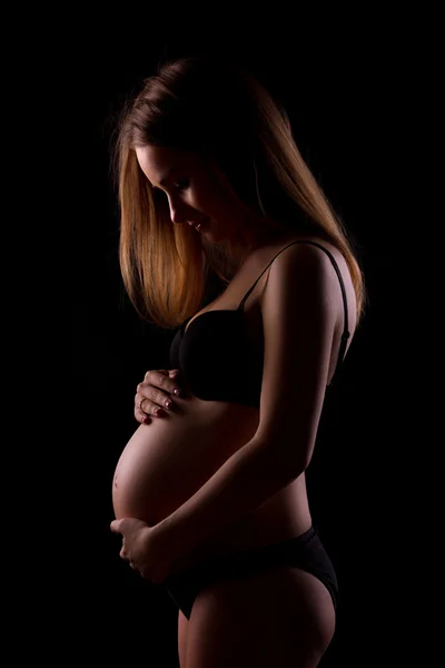 Young pregnant women on black background — Stock Photo, Image