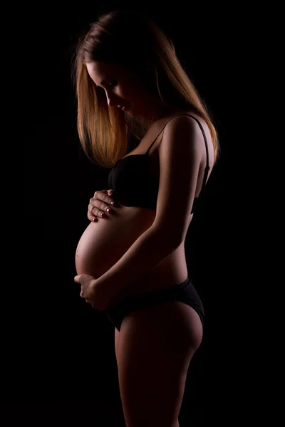 Siyah arka plan üzerine genç hamile kadınlar — Stok fotoğraf