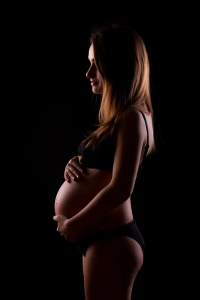 在黑色背景上的年轻孕妇 — 图库照片