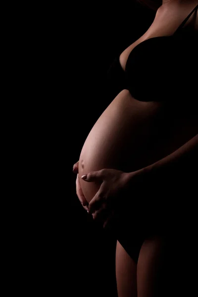 Lichaam van de jonge zwangere in zwarte ondergoed — Stockfoto