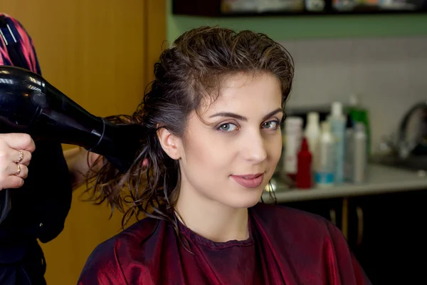 Jong meisje in kapsalon dressing droogt haar haar — Stockfoto