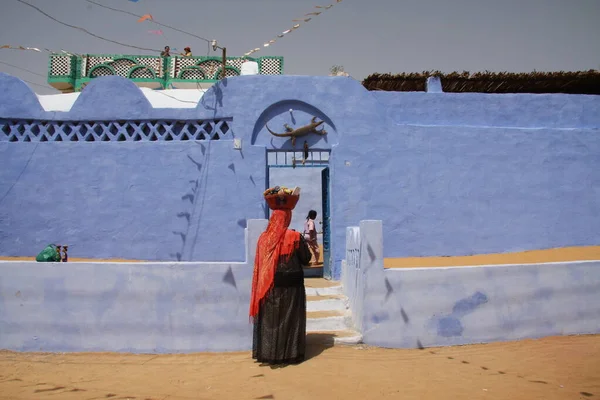 En man i traditionell klänning bredvid ett traditionellt nubianskt hus, Nubia, södra Egypten, augusti 2015 — Stockfoto