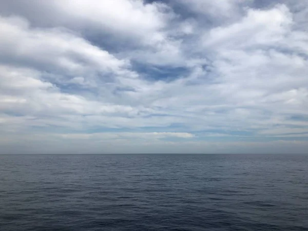 Nuvole blu scuro e superficie d'acqua marina o oceanica con onde di schiuma prima della tempesta, drammatico paesaggio marino — Foto Stock