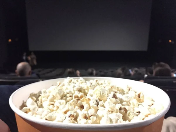 Schienali di sedili vuoti in un cinema con una ciotola di popcorn — Foto Stock