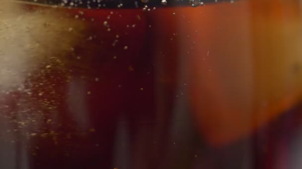 Macro-glaces extrêmes tourbillonnent dans le soda foncé — Video