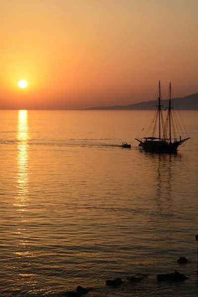 Pôr do sol sobre o mar Egeu com barco Imagens De Bancos De Imagens