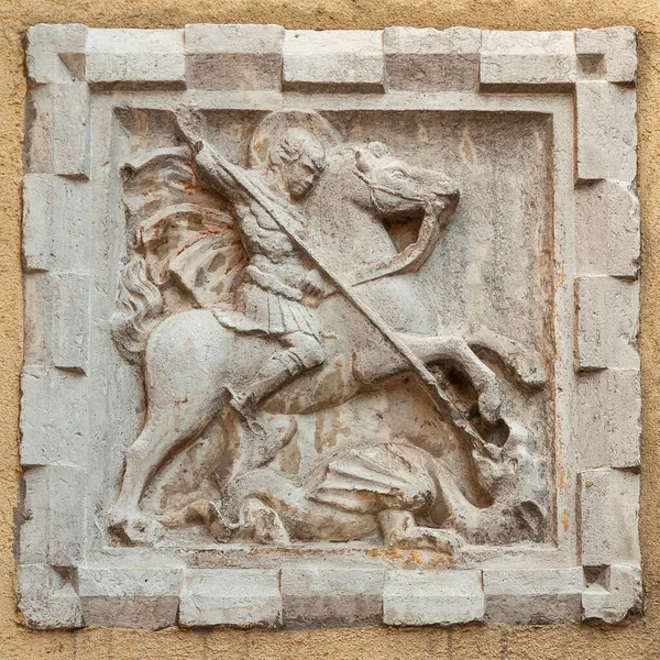 St George fights and kill the evil Dragon old relief on a Venice wall