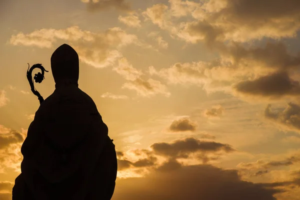 キリスト教の宗教と精神性 ビショップ古代の像シルエットとともにクロエに対して夕日の空 — ストック写真