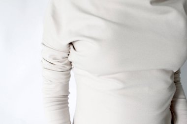 Yakından örülmüş beyaz formalı bir elbise. Kumaşların etkisi. Konsept: moda, kendi giyim markanız, dükkan, atölye, tasarım.