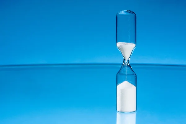 Hourglass with blue background — Stock Photo, Image