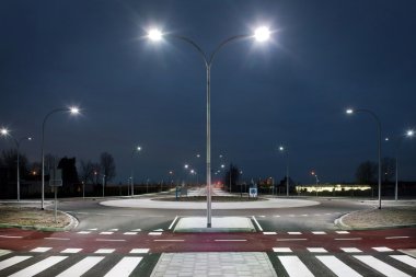 Roundabout illuminated by led lights  at twilight clipart