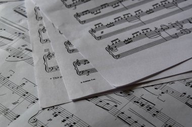  Sayfa müzik ve müzik notaları, düzensiz bir şekilde duran kağıtlara yazılmış güzel eserler..