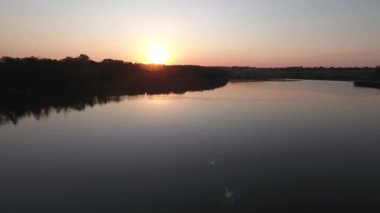 Gölün üzerinde gün batımı. Sudaki yansıma..