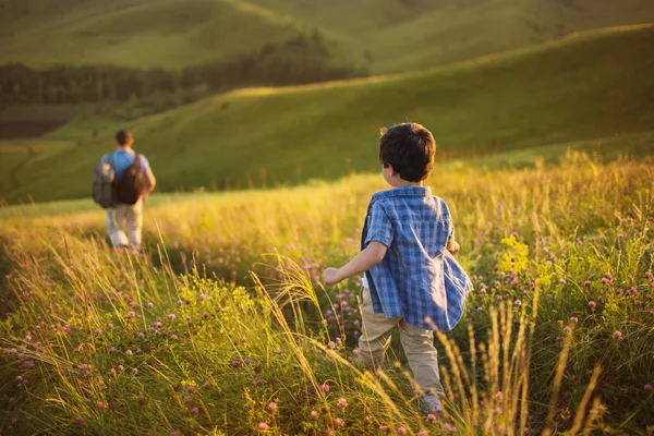 Маленький мальчик следует за своим отцом на поле — стоковое фото