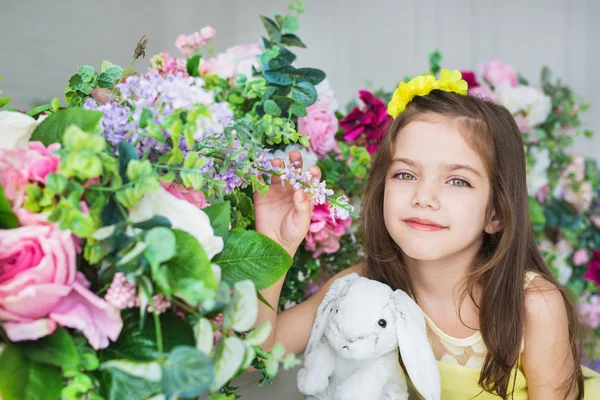 Szép kislány, egy nyúl játék közelében, egy virágot, egy stúdióban portré — Stock Fotó