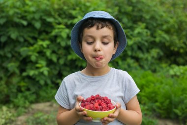 Sevimli küçük çocuk gibi yemek için bir çilek ile ve kendini yala