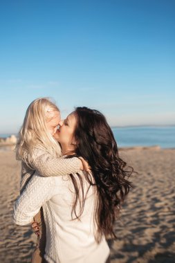 Anne üzerinde ellerini tutar ve küçük kızı öper