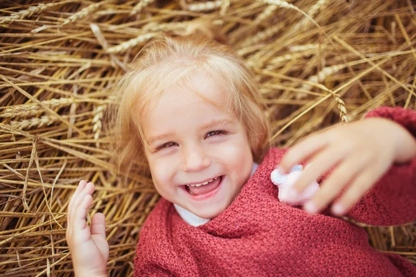 Πορτρέτο του ένα μικρό γελαστό κοριτσάκι βρίσκεται στα αυτιά του σίτου — Φωτογραφία Αρχείου