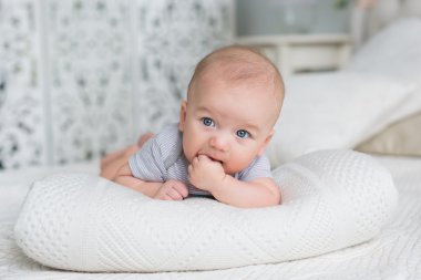 Şirin Bebek evde bir yatakta yatıyor ve parmağını emmek