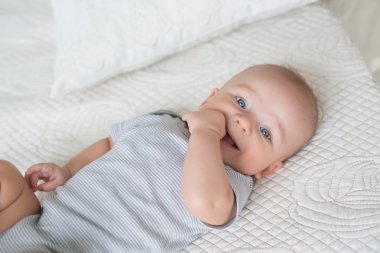 Bir yatakta gülümseyen bebek portresi