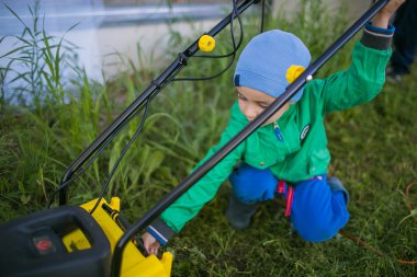 Çim biçme makinesi şirin küçük çocuk açmak