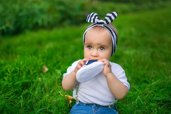 Πορτρέτο του ένα μικρό μωρό μασά παπούτσι του σε ένα χόρτο — Φωτογραφία Αρχείου