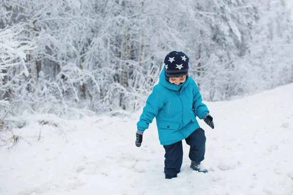 Un bambino carino cammina su una neve in inverno — Foto Stock