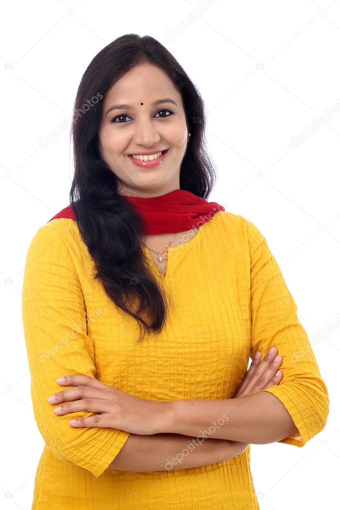 Smiling young woman with arms crossed against white