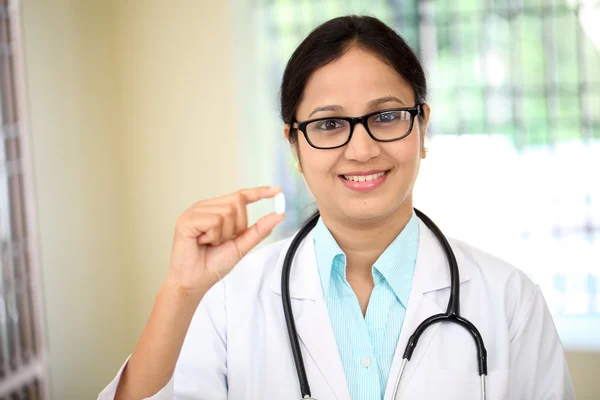 Doctora joven sosteniendo una píldora —  Fotos de Stock