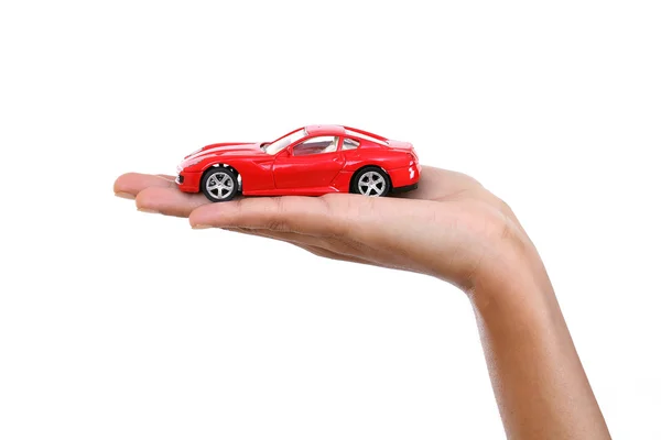 Αυτοκίνητο κόκκινο παιχνίδι στο χέρι ενάντια σε λευκό φόντο — Φωτογραφία Αρχείου