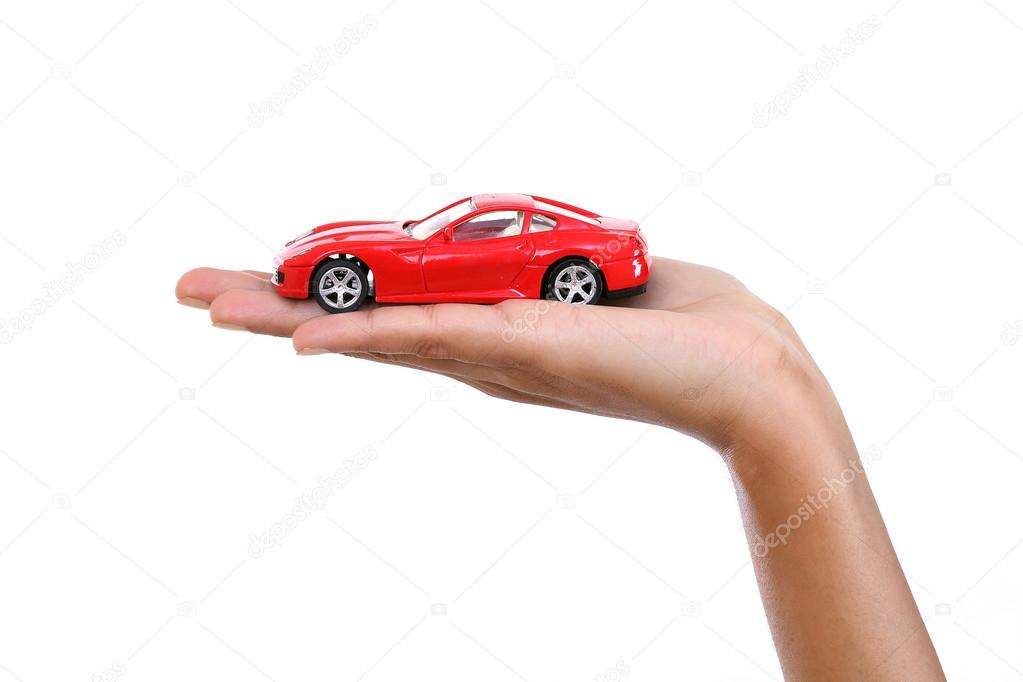 Red toy car in the hand against white background