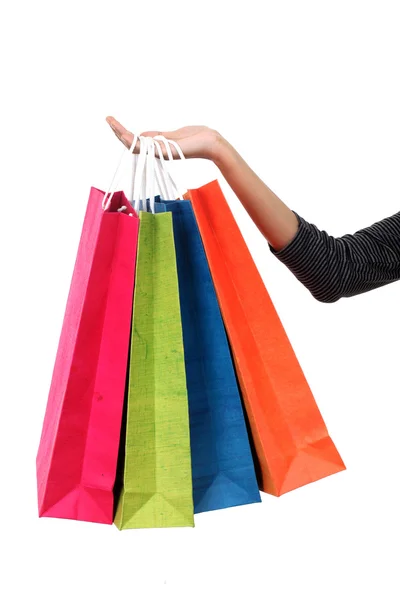 Mano femenina sosteniendo coloridas bolsas de compras contra blanco —  Fotos de Stock