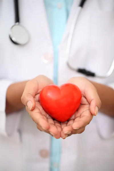 Femme médecin tenant une belle forme de coeur rouge — Photo
