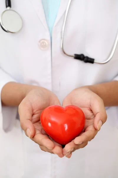 Female doctor holding a beautiful red heart shape — Stock Photo, Image