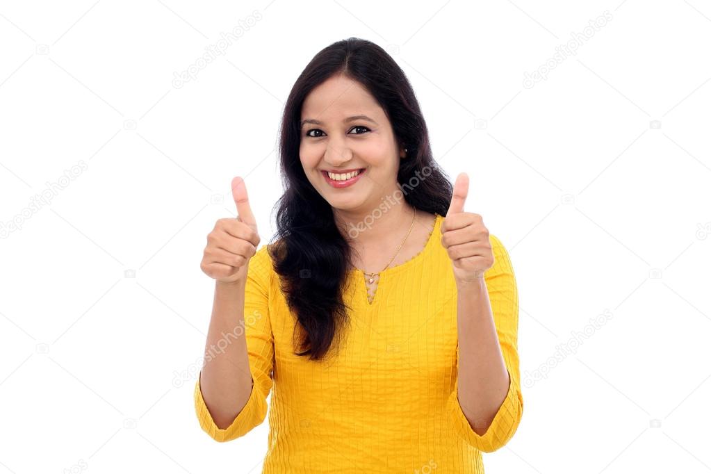 Cheerful young woman showing thumbs up gesture