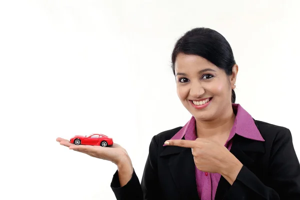 Happy young business woman holding toy car — Stock Photo, Image