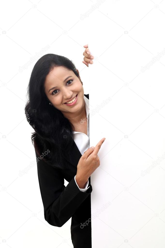 Young cheerful business woman showing a blank sign board