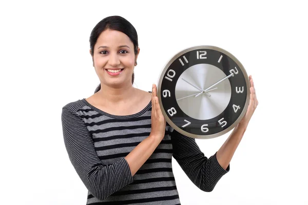 Wesoły młoda kobieta trzyma urząd zegar — Zdjęcie stockowe