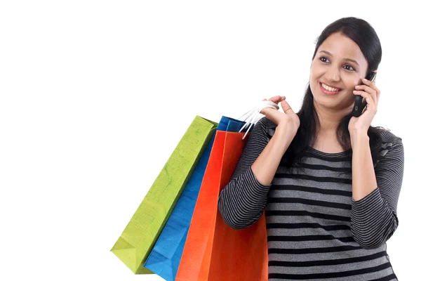 Junge Frau mit Einkaufstüten und Handy im Gespräch — Stockfoto