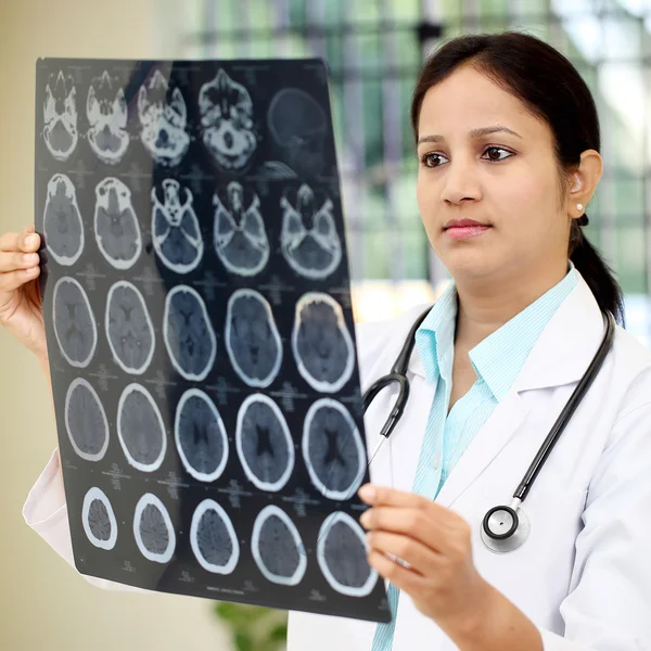 Kadın doktor beyin bilgisayarlı tomografi inceleyerek inceden inceye gözden geçirmek