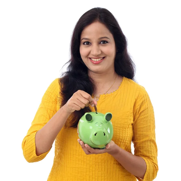 Jonge vrouw bespaart geld in Piggy bank — Stockfoto