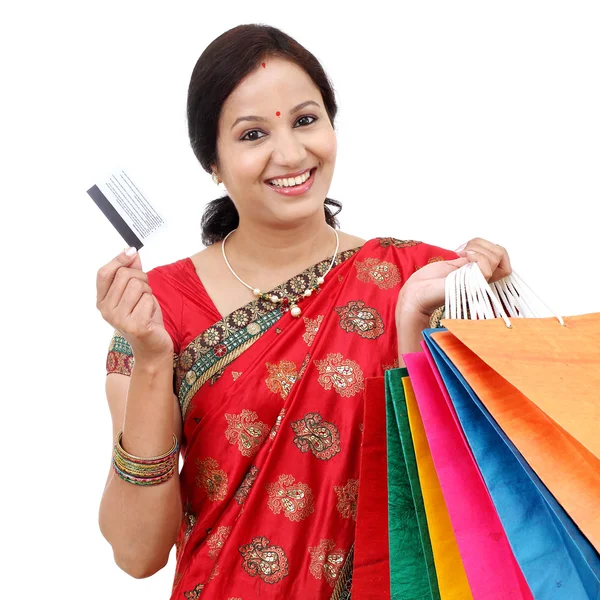 Молодая улыбающаяся традиционная женщина с сумками для покупок и кредит ок — стоковое фото