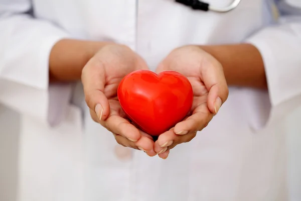 Femme médecin tenant une belle forme de coeur rouge — Photo