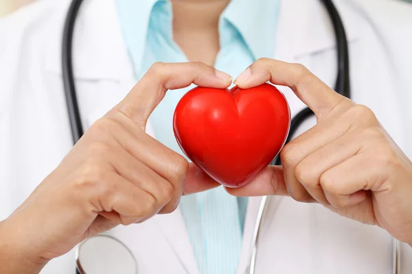 Female doctor holding a beautiful red heart shape — Stock Photo, Image