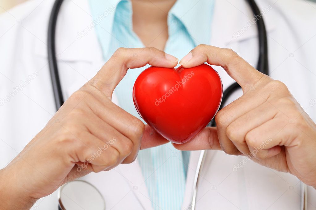Female doctor holding a beautiful red heart shape 