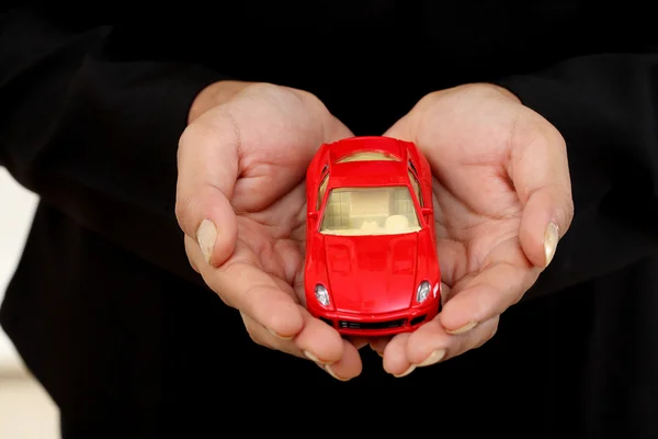 Business woman with a toy car in her hand — Stock Photo, Image