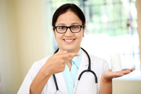 Female doctor holding up a bottle of tablets — Stock Photo, Image